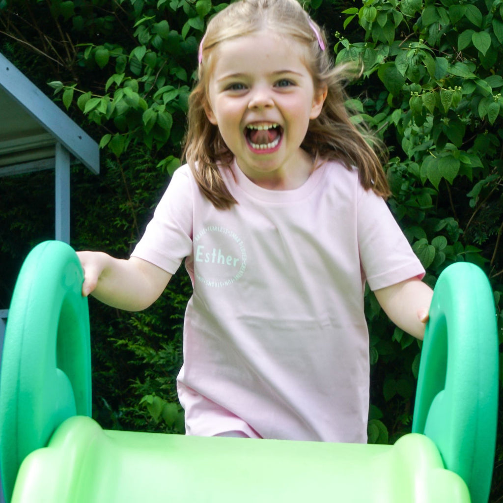 Short sleeve affirmation shirt for girls, in pink with words like "fearless", "smart", "loved", "creative", "fun", "strong"