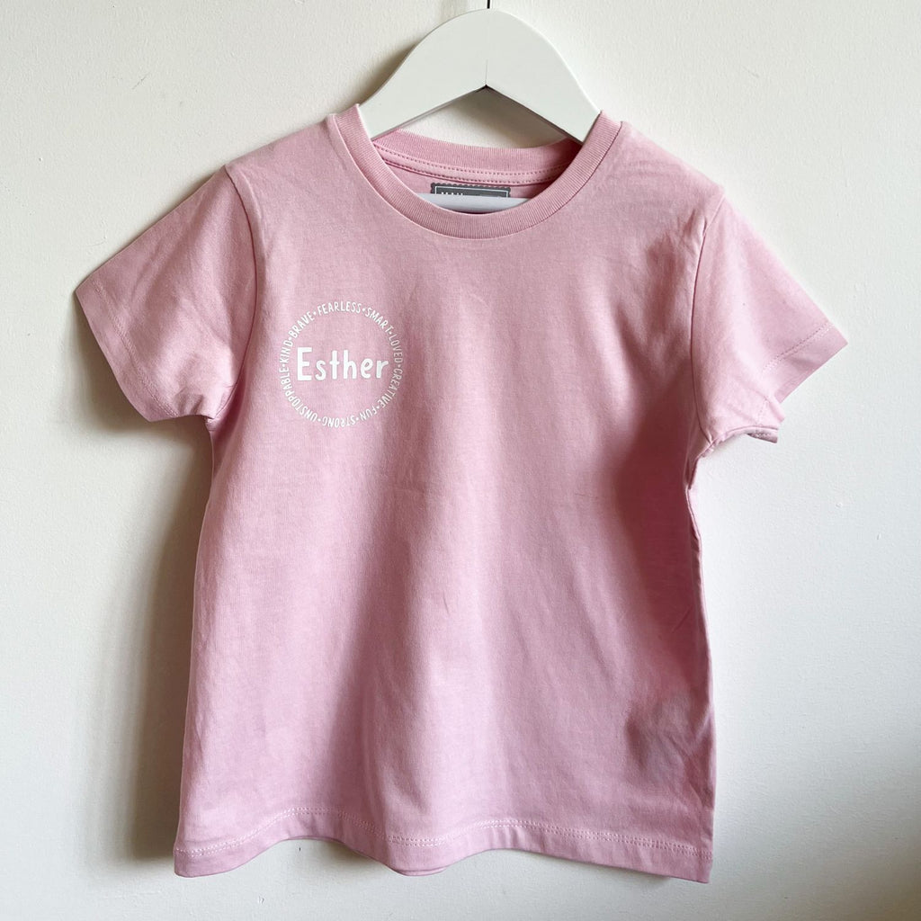 Personalized affirmation t-shirts for kids, including words like "fearless", "smart", "loved", "creative", "fun", "strong"